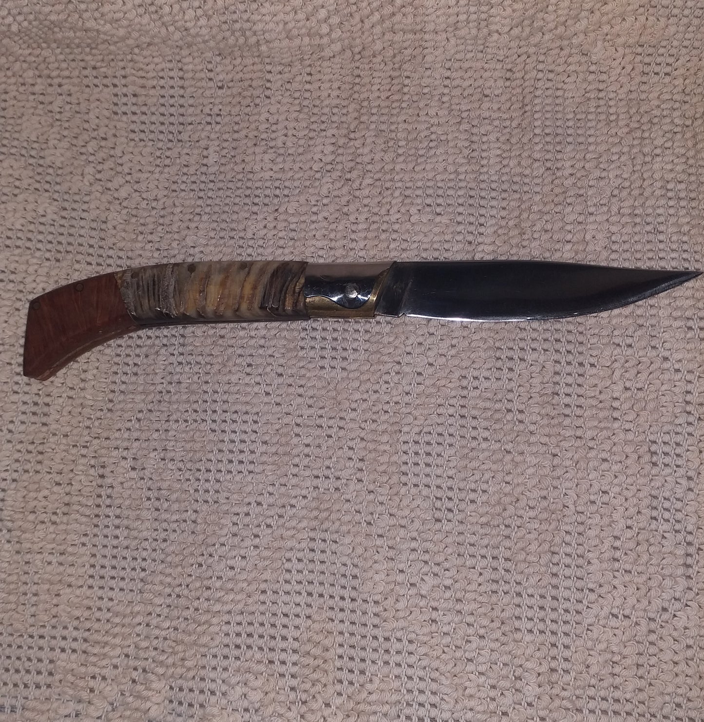 Coltello pattadese con anima decorata ,lama 12 CM ,impugnatura in corno di montone striato e radica