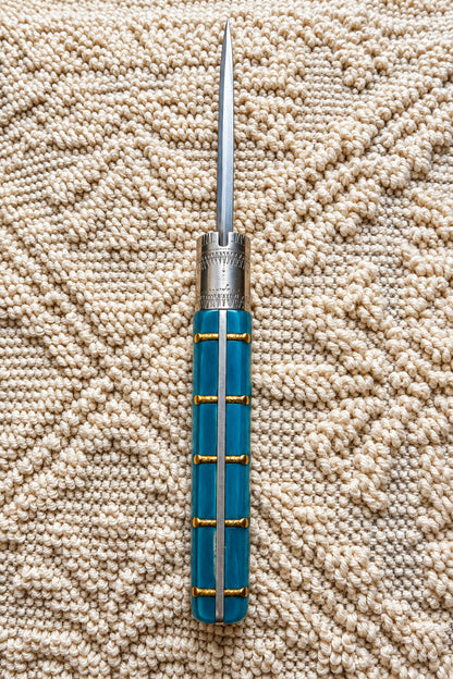 Coltello  pattadese con anima  , lama liscia 10,5CM  impugnatura in resina colore oceano,con la Sardegna e il sole incastonati.