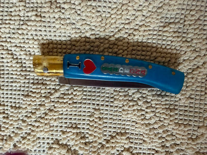 Coltello  pattadese con anima  , lama 10,5 CM  impugnatura in resina colore oceano,con scritta I love Sardegna.